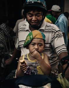 a little boy with his father on scooter in vietnam